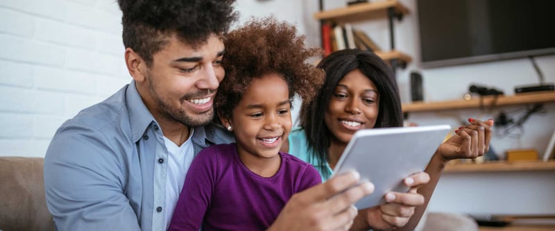 Young family watches a church live stream online on a tablet at home