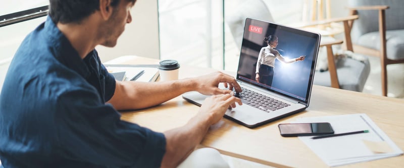 Man watching a live stream video on his laptop