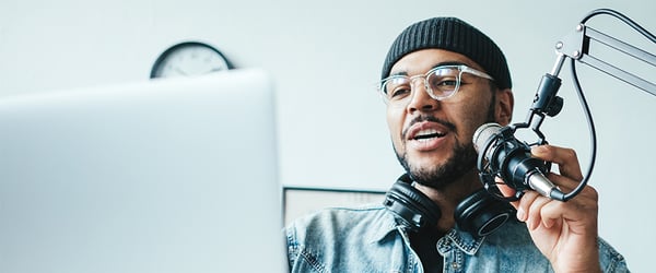 Man speaking into a microphone while live streaming on a computer