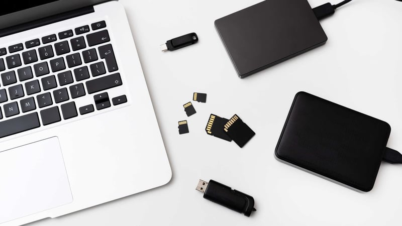 Memory cards laid out on desk with a laptop