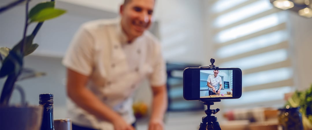 Chef filming himself on a cooking live stream with his phone