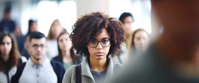 somber looking young woman in a busy crowd