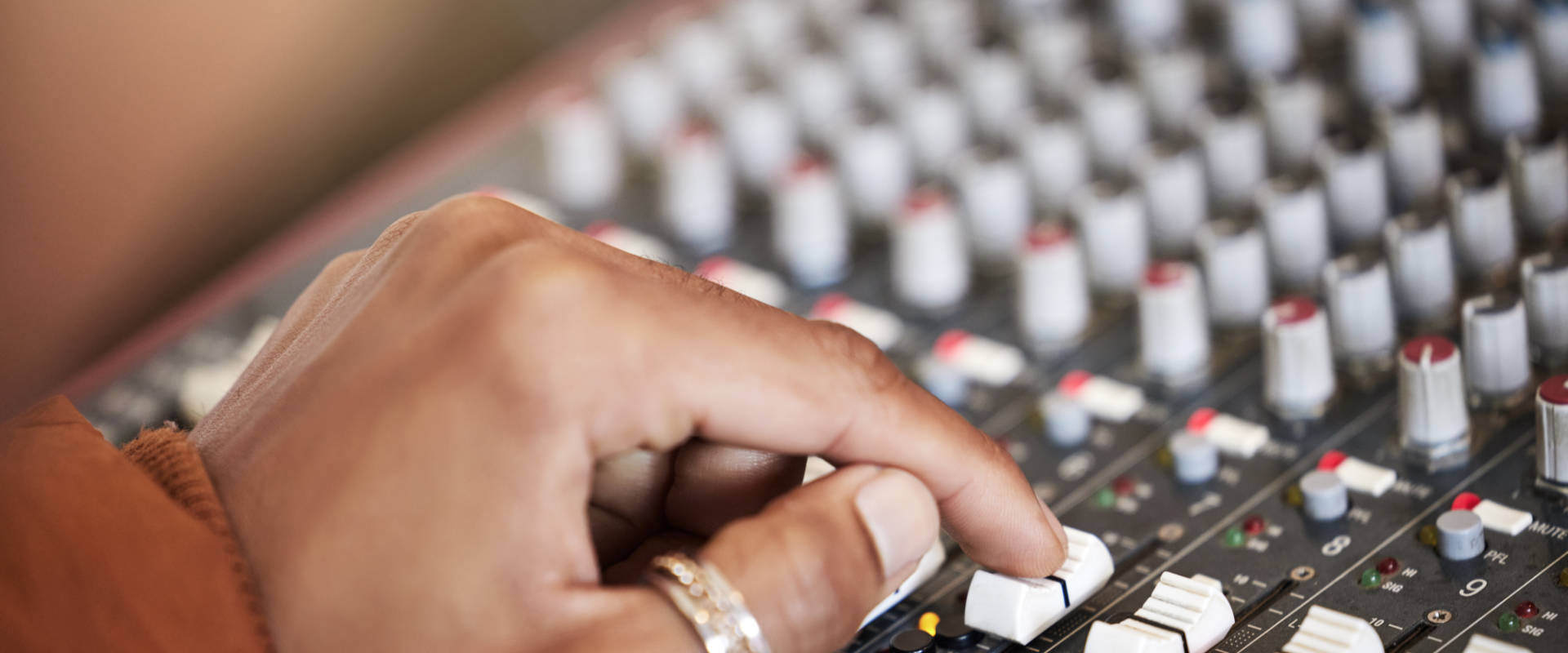 Person's hand adjusting audio on mixer