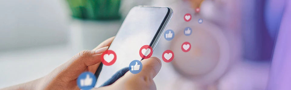 Person holding a smartphone with social media likes and reactions