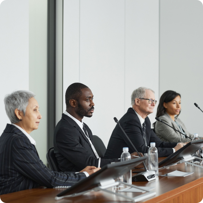 Four people sitting in a government meeting