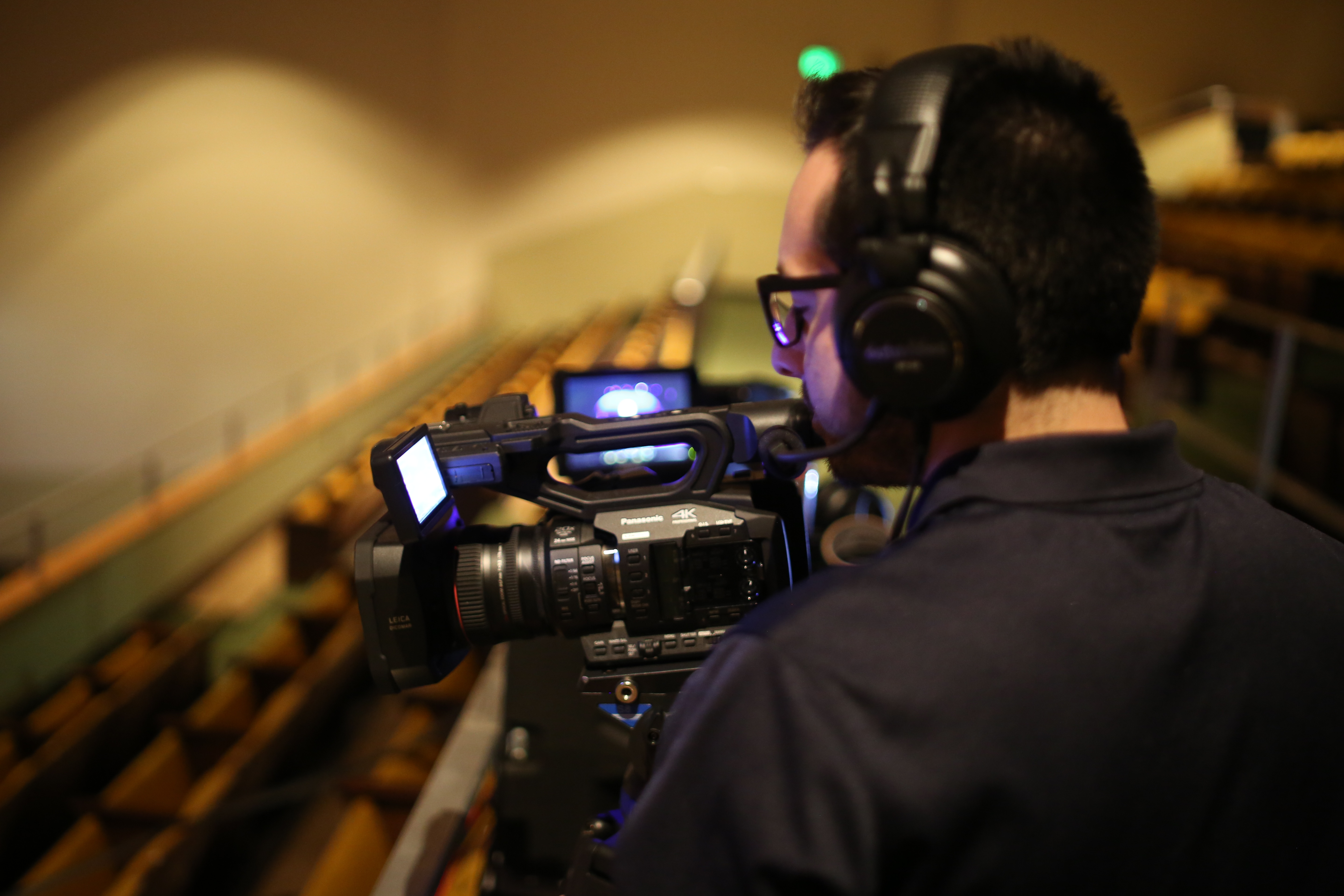 Man with headphones on shoots with a video camera