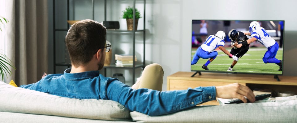 Man watching live stream football game on a smart TV