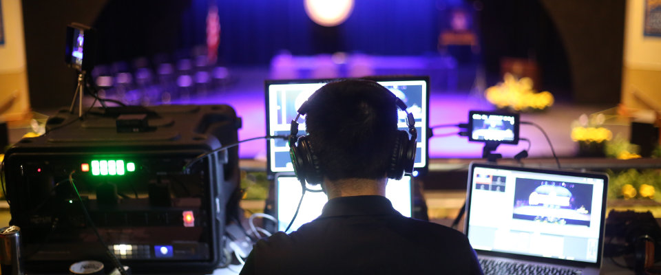 Video producer managing live broadcast at production table