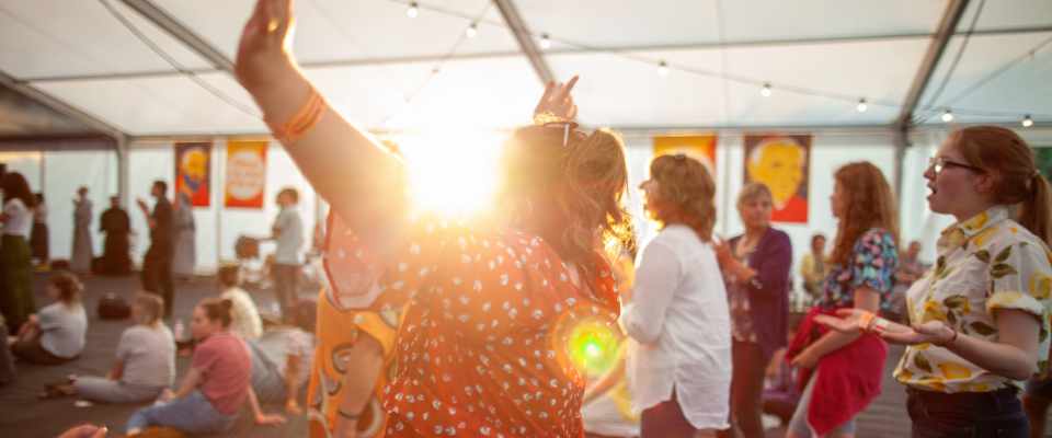 Church service taking place outside under a tent