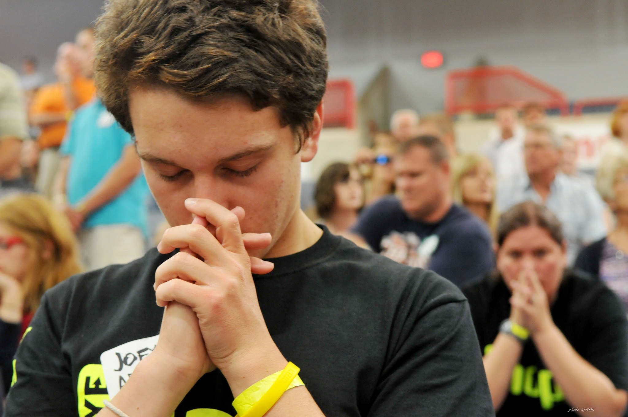 Man praying in a crowd of people